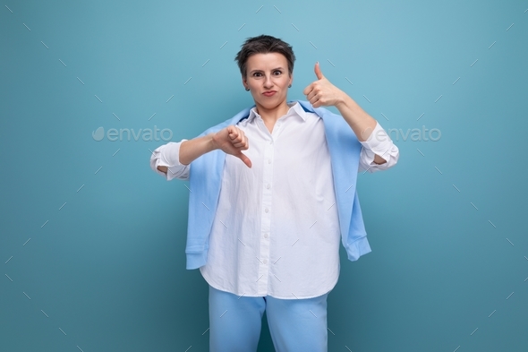 energetic positive young brunette woman with short haircut in white shirt showing like and dislike