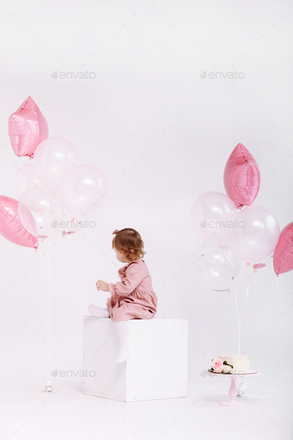 happy birthday 2 years old little girl in pink dress. white cake with ...