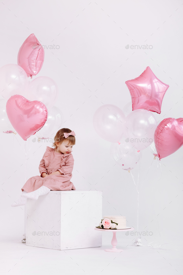 Happy Birthday 2 Years Old Little Girl In Pink Dress. White Cake With 