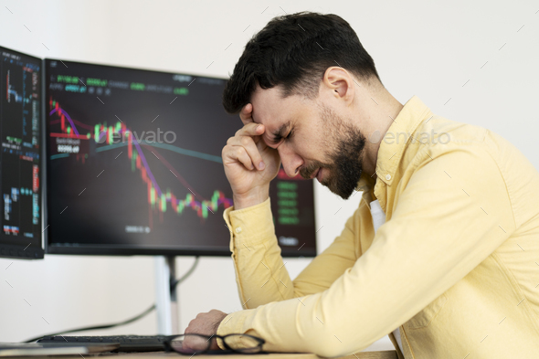 Tired bearded man, trader having headache, lost money sitting in office. Failure business