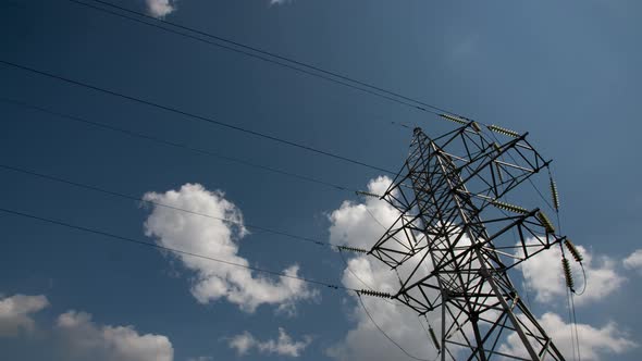 Power Transmission Lines High Voltage Electricity Grid with Cloudy Blue Sky on Background alt