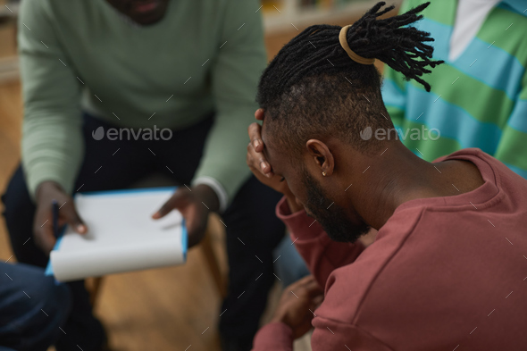 Troubled black man crying in support group