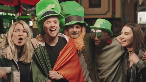 Cheerful Friends Celebrating St Patricks Day At Pub alt
