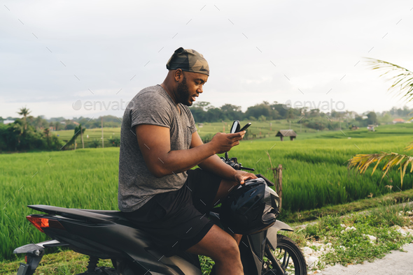 Millennial male user checking location information during online GPS tracking via modern cellphone g