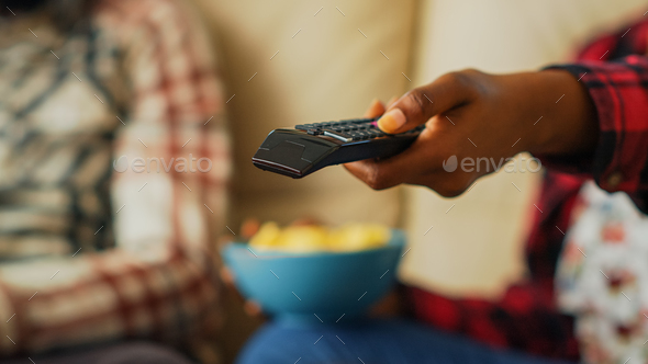 Woman switching channels with tv remote control