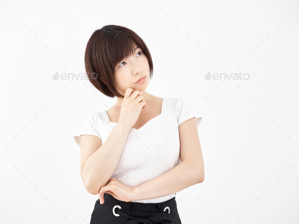 A woman holding her hand to her chin on a white background, wondering which one is better