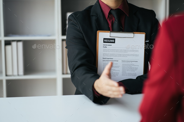 Close up view of applicant presenting his resume to the employer during the job interview.