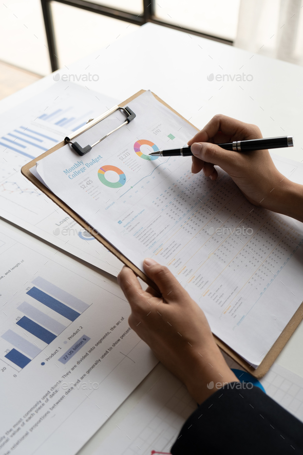Close up view of young businesswoman working on her project with graph and charts, analyzing the - Stock Photo - Images