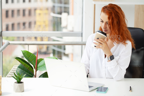 Red Haired Positive Cute Beautiful Business Woman Sit Indoors In Office