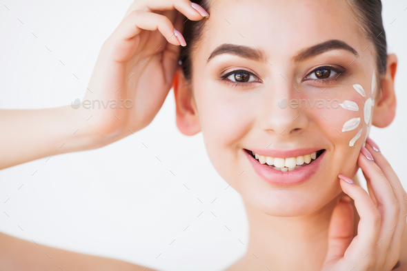 Sun Tanning. Beauty Girl Applying Sun Tan Cream on her Face. Stock ...