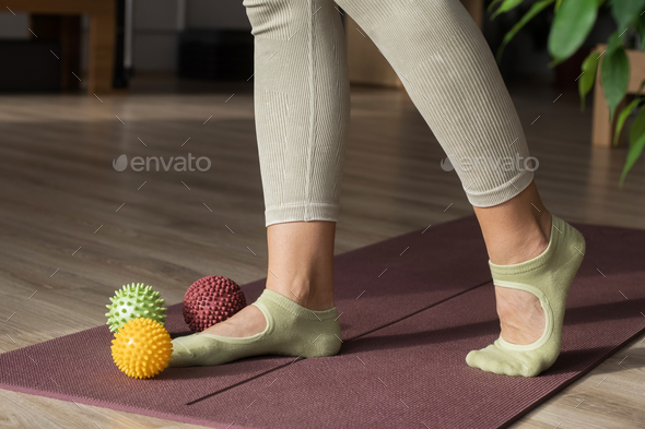 Trainer doing leg stretching exercises with fitness rubber balls. Fitness trainer doing exercises in