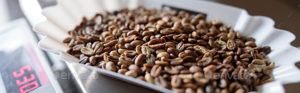Bowls of roasted coffee beans on electronic scales