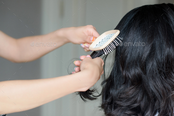 close-up hand combing hair with a comb. hairdresser services