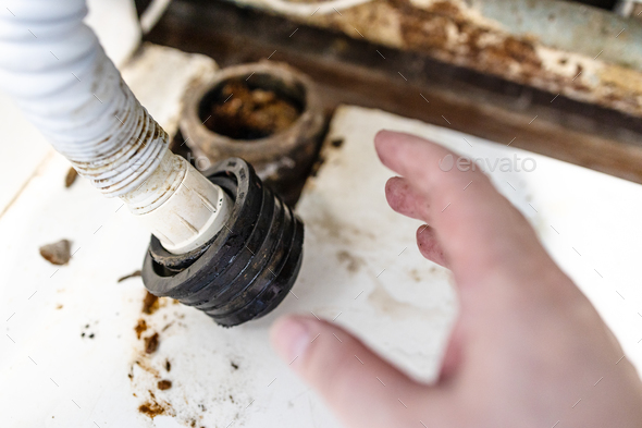 hand of plumber near corrugated drain hose closeup