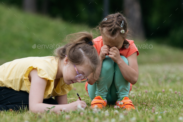 Girl crying in park while playing with friend.
