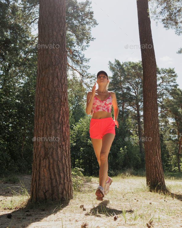 sporty woman runs in forest among trees. fitness, yoga for health of body and mental state
