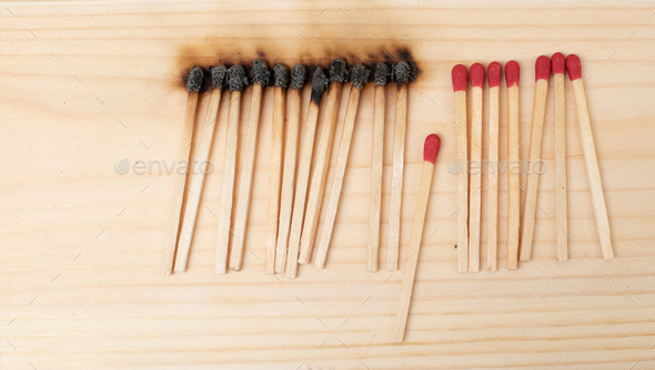 Row of burning matches and all matches on white background