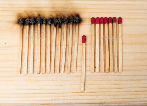 Row of burning matches and all matches on white background