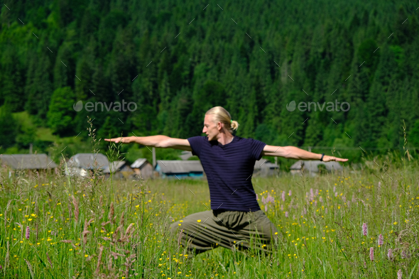 Young man practicing yoga exercises in green nature - Stock Photo - Images