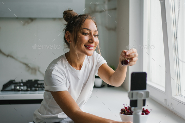Female nutritionist blogger leads a live broadcast or video conference about the benefits of berries