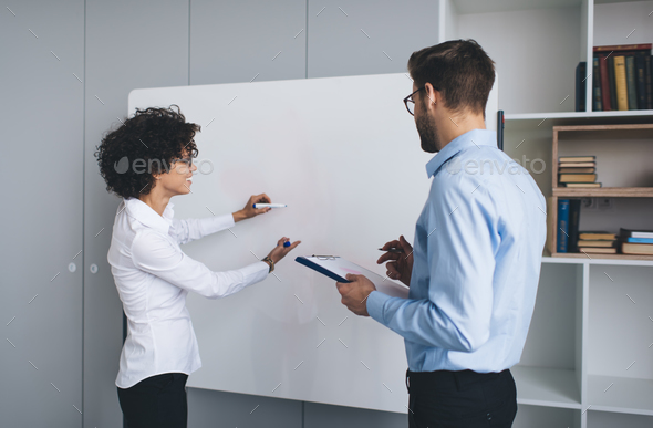 Business man and woman work at interactive board