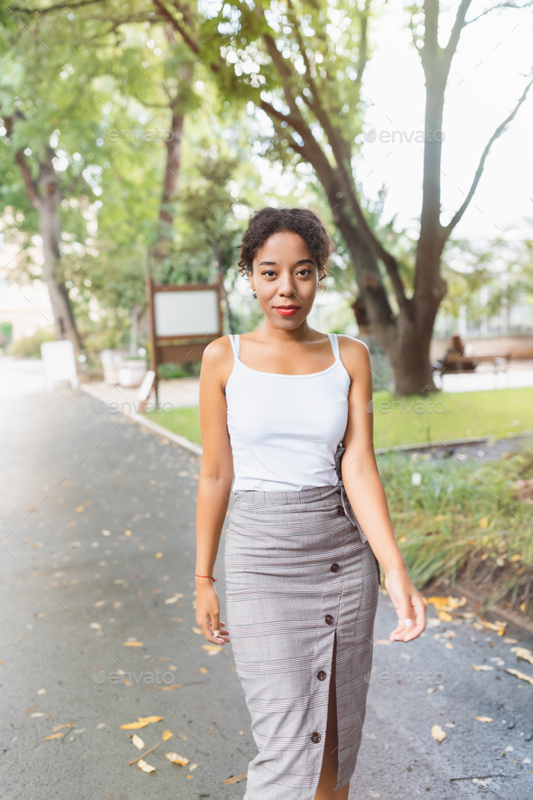 Young African American woman in park, white shirt mock up. Fall season