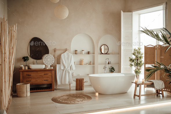 Luxury interior of big bathroom at modern african style with oval bathtub in natural lighting - Stock Photo - Images