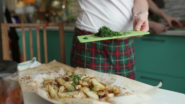 Crop Person Adding Herbs on Freshly Prepared Potatoes in Kitchen