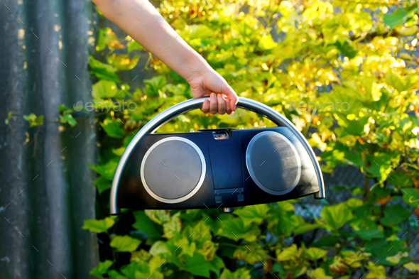 Boombox. Defocus hand holding retro music recorder on nature. Retro outdated portable stereo boombox