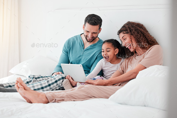 Mom, dad and child on bed with tablet, watching movies, streaming service for child development and