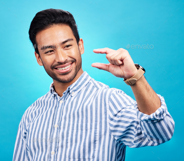 Small, hand and gesture of a man with a smile in studio showing a tiny