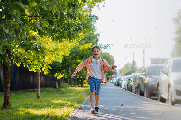 caucasian boy running to school wearing school bag. Begining of ...