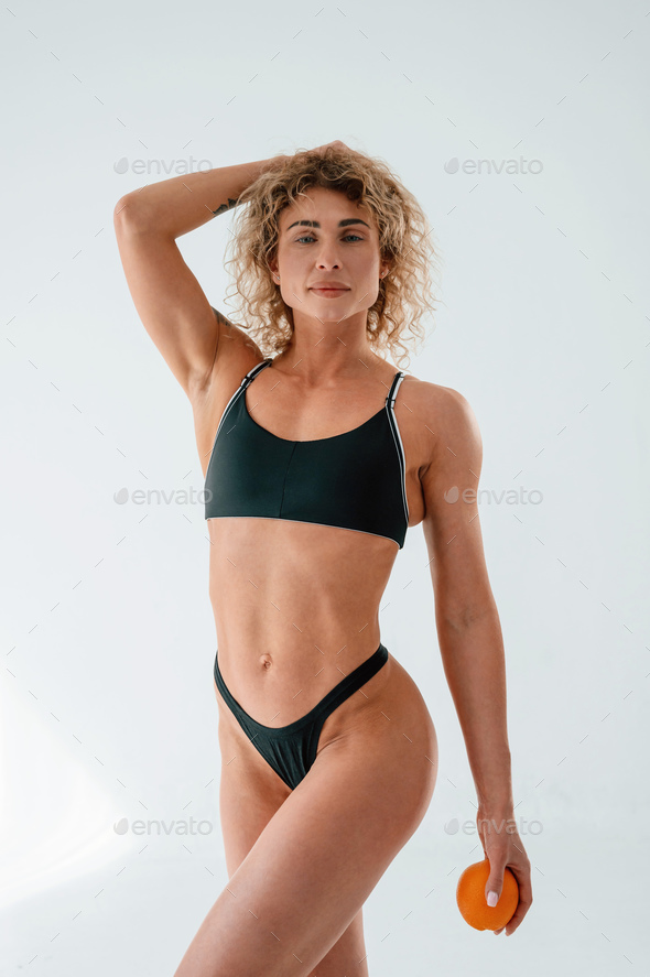 Young caucasian woman with athletic body shape is indoors at