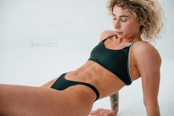 On the hands and legs. Young caucasian woman with athletic body shape is  indoors at daytime Stock Photo by mstandret