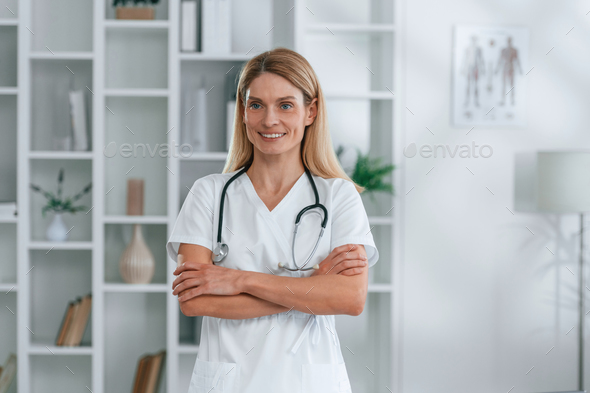 Young Female Nurse With Folded Arms Standing In Hospital Stock