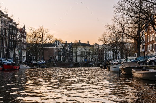 Aesthetic canals of Amsterdam at sunset, view from the water
