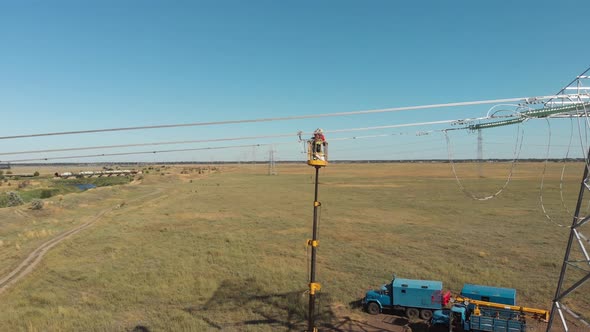 Technician Repairs Power Transmission Lines Against Fields