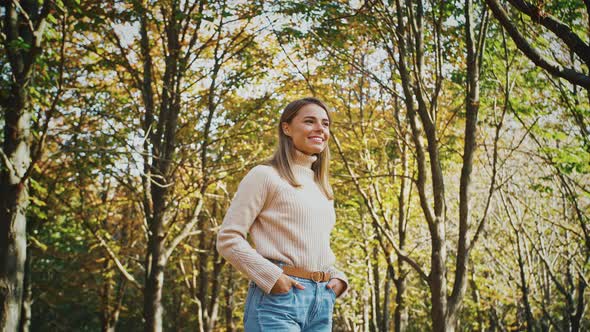 Young Attractive Lady Smiling and Looking at you While Posing with Her Hands in Pockets Standing at alt