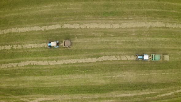 Aerial View of Two Tractors Collecting Crop Straw and Making Haystacks in Baler