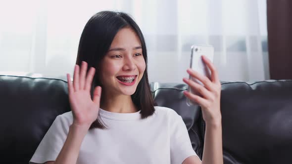 Woman in a white t-shirt making video call online talking with friends. alt