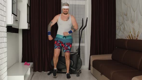 Sportsman Guy Pointing at Camera Running in Place at Home Making Sport Fitness Cardio Exercises alt