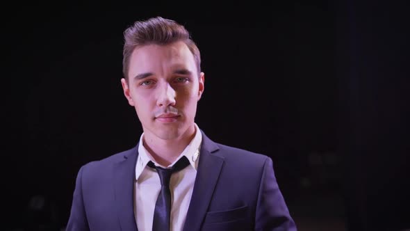 Young Handsome Brunette Magician Man in Stage Costume with His Trained White Doves. Magician Stands alt