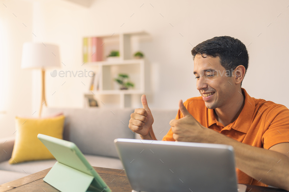 Worker with thumbs up during a online meeting at home