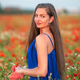 portrait of elegant young woman in poppy field in evening sunlight - PhotoDune Item for Sale