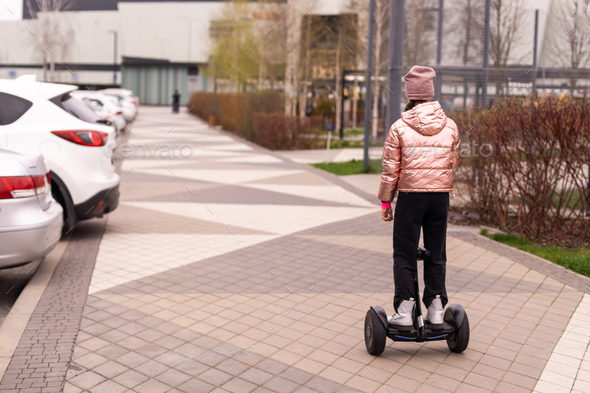 Young girl riding electric mini segway hover board scooter. ecological urban transportation