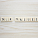 Our Values letter tiles on a wood grain background - PhotoDune Item for Sale