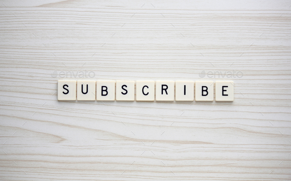 Subscribe letter tiles on a wood grain background - Stock Photo - Images
