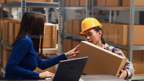 Asian guy organizing boxes with supplies on shelves Stock Photo by DC_Studio