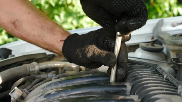 Auto Mechanics in Gloves Repairing Car at Service Station alt