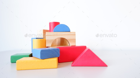 Closeup of colorful wooden toy blocks and figures on a white background